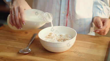 女人手倒牛奶玉米片碗女人吃麦片首页